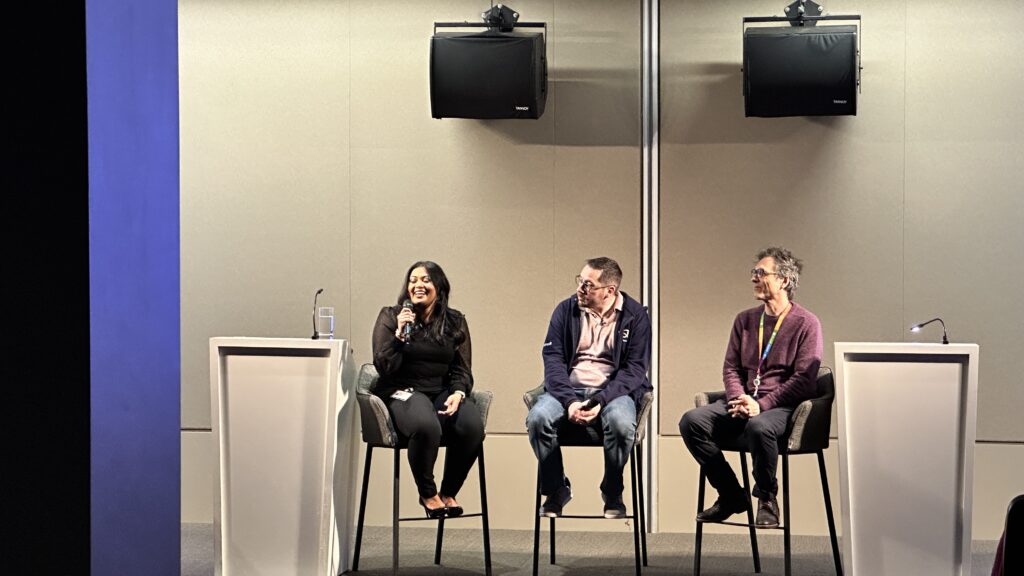 Anika Zubair speaking at Microsoft CSAM Learning Hour event with a microphone in her hand on a panel